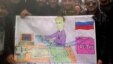 Syrians in the northwestern town of Kfar Nubul pose with a cartoon depicting Russia