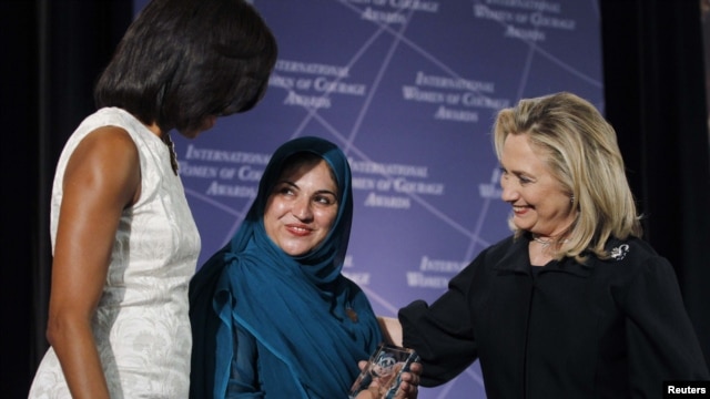 First Lady Michelle Obama (left) and U.S. Secretary of State Hillary Clinton (right) congratulate Shad Begum of Pakistan during the U.S. State Department's 2012 International Women of Courage Award winners' ceremony on March 8.