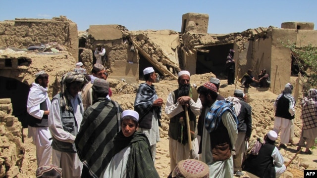  Villagers search for dead bodies of those killed in a NATO air strike in the village of Sajawand in Logar Province on June 6.