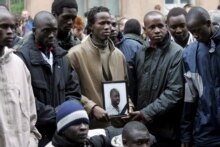 Russia -- Friends of a student from Senegal who was killed early 7 April hold his picture during a rally in his memory in St. Petersburg, 8 Apr. 2006