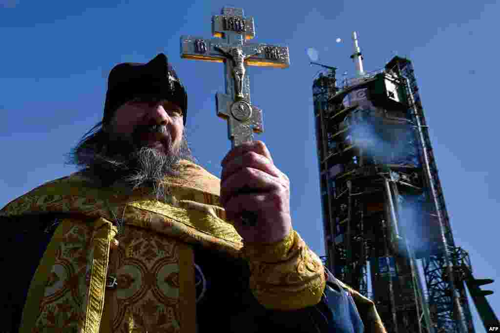 A Russian Orthodox priest conducts a blessing in front of the Soyuz TMA-20M spacecraft at the launch pad of the Russian-leased Baikonur Cosmodrome in Kazakhstan on March 17. (AFP/Kirill Kudryavstev)