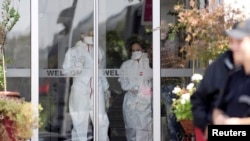 Medical personnel leave a quarantined hotel in Skopje, Macedonia, after a man was taken to hospital with symptoms associated with the Ebola virus.