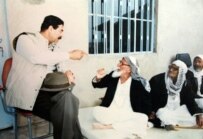 Saddam Hussein (left) drinks tea with elders in Mosul in 1993 (AFP)