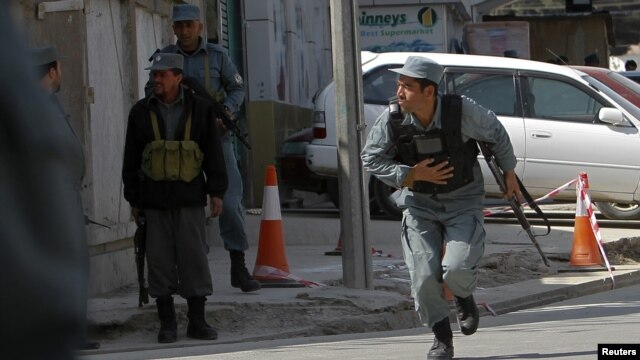 Afghan police officers take up positions during the attacks in Kabul on April 15.
