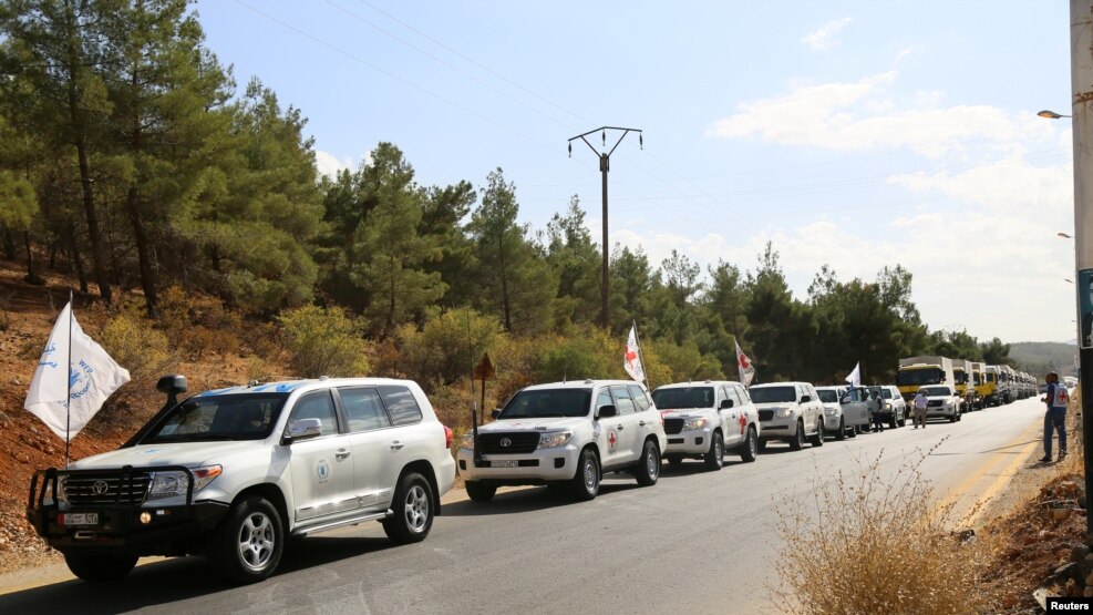 A convoy carrying food and humanitarian supplies waits as they head to deliver aid to Syrian besieged towns, near Damascus, in September.