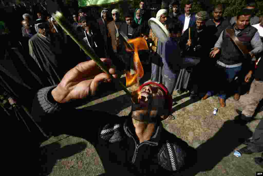 An Iraqi Muslim eats fire during a Sufi ritual, attended by Sunni and Shi'a, in the city of Hilla, south of Baghdad, on January 15. (AFP/Haidar Hamdani)