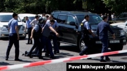 Полиция шабуылдан соң ер адамды тұтқындап әкетіп барпады. Алматы, 18 шілде 2018 жыл.