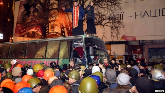 Шерушілер ішкі істер министрлігі өкілдері отырған автобусты тоқтатып тұр. Киев, 21 ақпан 2014 жыл.