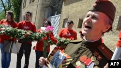 A World War II veteran wearing a Soviet officer uniform sings during a march in the center of Kyiv to celebrate Victory Day on May 9 2013.