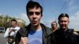 Roman Dobrokhotov (center) is detained by the police outside the Christ the Savior Cathedral in Moscow.