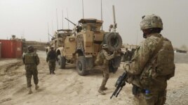 U.S. troops guard the entrance of the base in Kandahar Province where the accused U.S. soldier was serving.