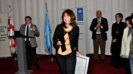 RFE/RL Tbilisi Bureau Chief Marina Vashakmadze (center) accepting the "Champion of Tolerance" award from Georgian Public Defender's Office head Beka Mindiashvili (left) during a ceremony in Tbilisi, 15Nov2012