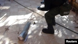 A UN chemical weapons expert gathers evidence at one of the sites of an alleged poison-gas attack in the southwestern Damascus suburb of Moadamyeh on August 26.