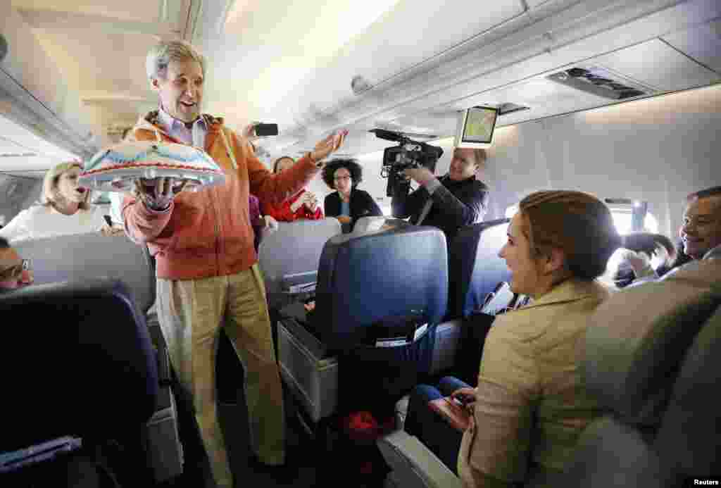 U.S. Secretary of State John Kerry presents a birthday cake to traveling CBS correspondent Margaret Brennan on his flight from Kabul to Paris. (Reuters/Jason Reed)