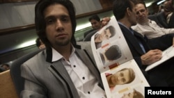 An Iranian hairstylist shows a brochure of official hairstyles in July 2010.