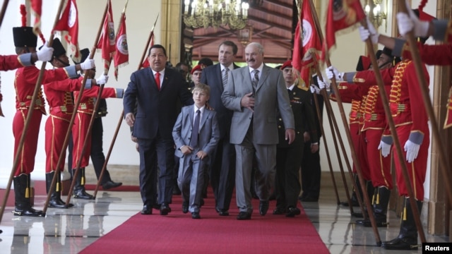 President Hugo Chavez (left) escorts his Belarusian counterpart, Alyaksandr Lukashenka, and the Belarusian president's son, Mykalay, at a welcoming ceremony at Miraflores Palace in Caracas on June 26.