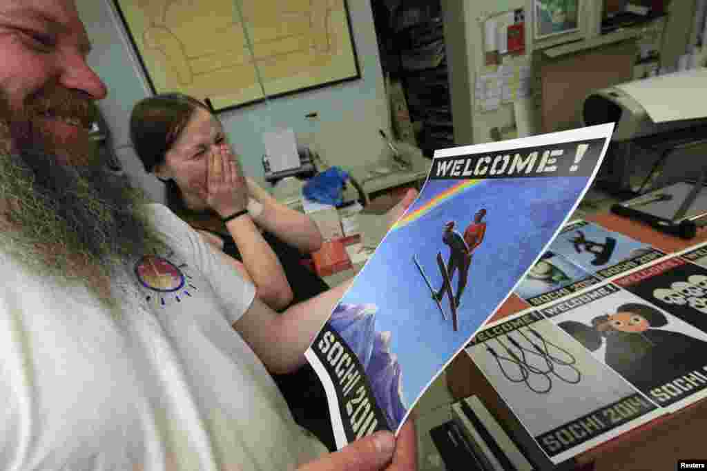 Vasily Slonov laughs over reproductions of his oil paintings from the series "Welcome! Sochi 2014."
