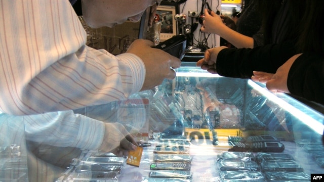 China -- A vendor sells various 'high imitation' iPhones at a shop in Beijing, 28Oct2009