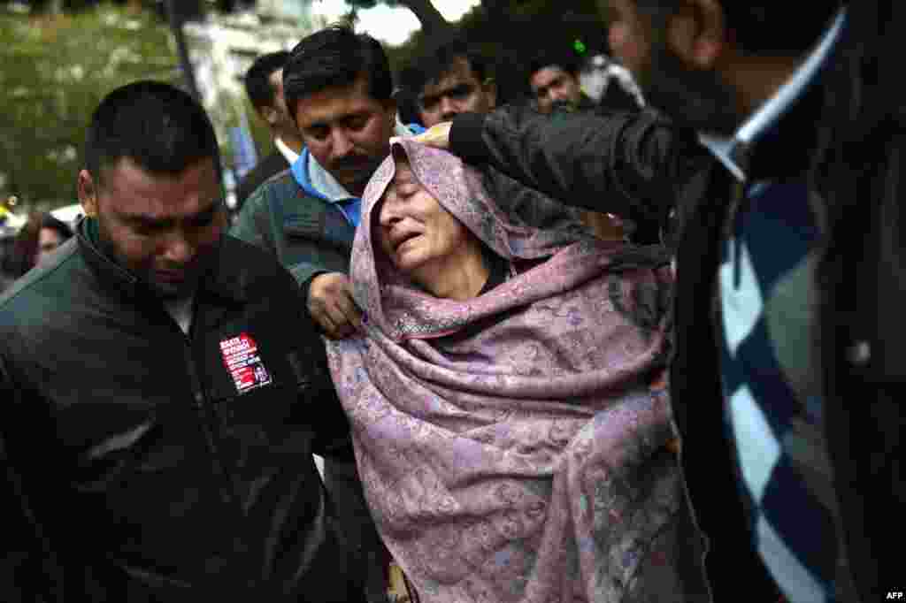The mother of a 27-year-old Pakistani man stabbed to death reacts as she leaves an Athens court where two suspected members of the Greek neo-Nazi party, Golden Dawn, accused of her son's murder, were scehduled to receive a verdict on December 18. (AFP/Aris Messinis)