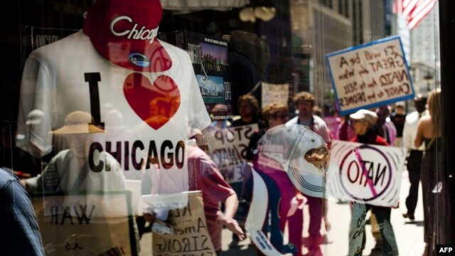  Demonstrators are reflected in a souvenir shop window in Chicago, Illinois, as peace activists march through the street demanding an end to NATO violence ahead of the summit.
