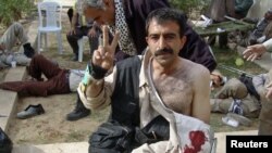 A camp resident gives the victory sign after clashes with Iraqi security forces at Camp Ashraf on April 8.