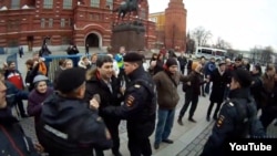 Moscow police detain Russians holding "invisible placards" of protest near the Kremlin on April 6.