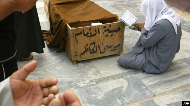 Iraqis pray at the coffin of a victim killed in a car bombing in Baghdad in April 2009.