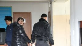 Полицейский уводит Гузяль Байдалинову, редактора сайта Nakanune.kz, после решения суда об аресте. Алматы, 26 декабря 2015 года.