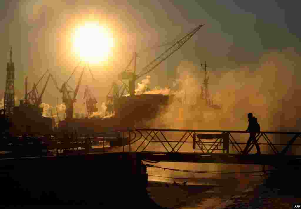 A man crosses a bridge at the Neva River embankment in St. Petersburg. (AFP/Olga Maltseva)