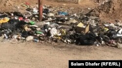 قمامة متراكمة في أحد شوارع العمارة