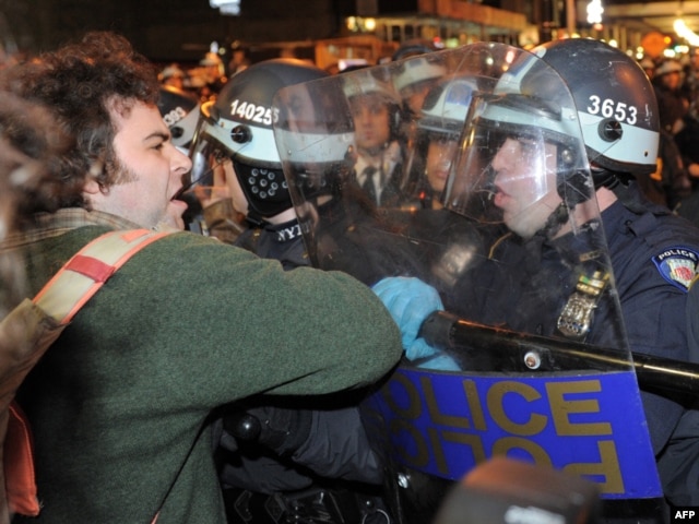 A protester is confronted by New York police officers as authorities cleared Zuccotti Park.