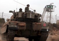 An Israeli tank passes by a UN post at the Lebanese border yesterday (epa)