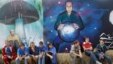 Activists sit near graffiti depicting Russian President Vladimir Putin at the summer camp of the pro-Kremlin youth group Nashi at Lake Seliger this past summer.