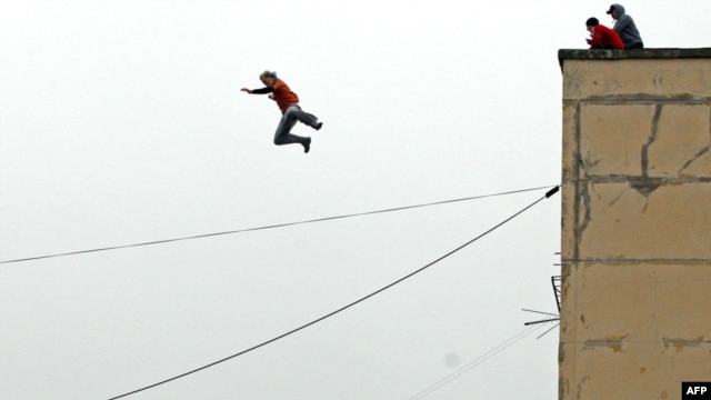 A parkour enthusiast jumps from the roof of an eight-story building to the roof of a five-story building in St. Petersburg.