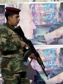 An Iraqi soldier in Baghdad passes posters promoting national reconciliation (epa file photo)