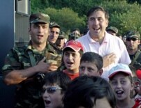 Georgian President Mikheil Saakashvili (right) sings the national anthem with reservists and children at a military training camp near Tblisi earlier this month (epa)