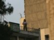 A gunman monitors the demonstrations from a rooftop.