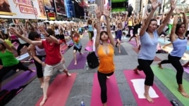 Participanţi la o sesiune practică yoga, Times Square, New York.