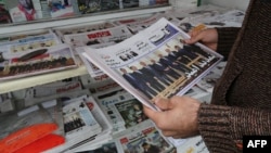An Iranian man looks at newspapers displayed outside a kiosk in the capital Tehran on November 25, a day after an extension to talks on the country's nuclear program was announced in Vienna.