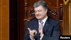 Ukrainian President Petro Poroshenko applauds during a session of parliament in Kyiv on June 19, during which deputies endorsed his nominations for key government posts.