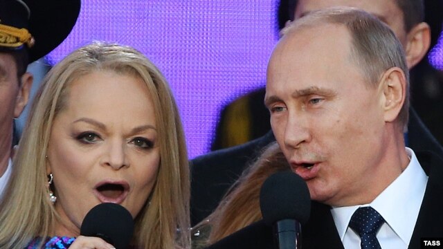 Президент Владимир Путин исполняет гимн России с Ларисой Долиной на концерте в Москве в марте прошлого года 