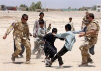 British soldiers playing football with children in Lashkar Gah in May (AFP)