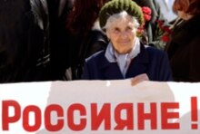 Moldova – Transdniester – Woman holds placard saying 
