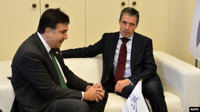 NATO Secretary-General Anders Fogh Rasmussen (right) meets with Georgian President Mikheil Saakashvili, whose party lost the recent elections, during the plenary session of a NATO Parliamentary Assembly in Prague on November 12.