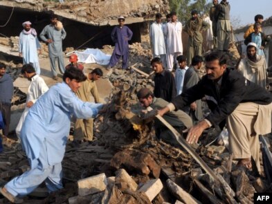 Pakistani volunteers and local residents search for blast victims in the rubble following the suicide car-bomb blast on the outskirts of Peshawar on November 16.