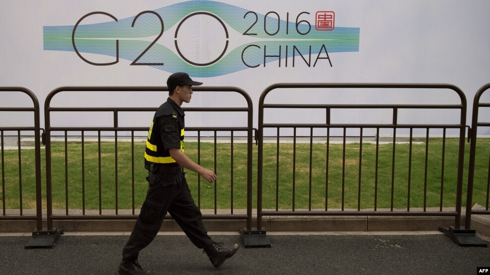 G20 саммиті өтетін Ханчжоу қаласында қонақүй жанынан өтіп бара жатқан қауіпсіздік қызметкері. Қытай, 2 қыркүйек 2016 жыл.