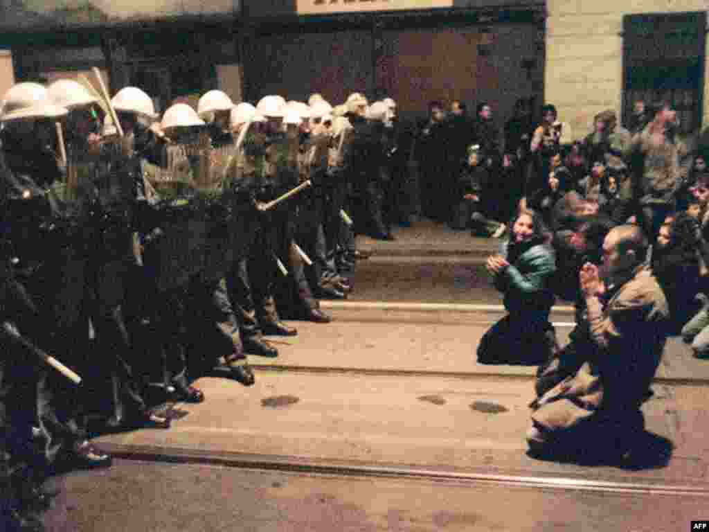 In this photo, also taken on November 19, protesters kneel as they face riot police in downtown Prague. The police again responded with violence.