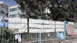 familjarët heqin fotografitë e personave të pagjetur nga rrethoja e Kuvendit të Kosovës, gusht 2012