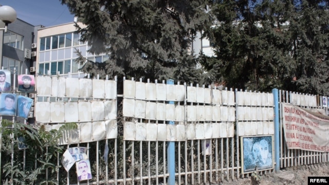 familjarët heqin fotografitë e personave të pagjetur nga rrethoja e Kuvendit të Kosovës, gusht 2012