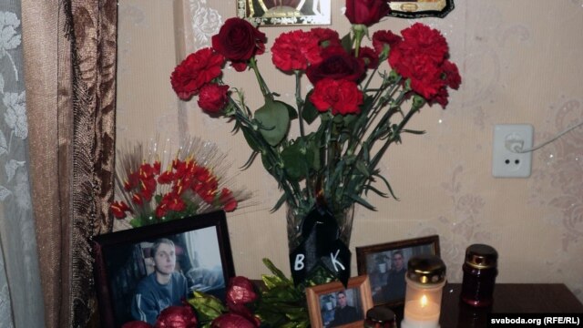 Flowers and photos of Uladzislau Kavalyou on a table in the apartment of his mother in Minsk